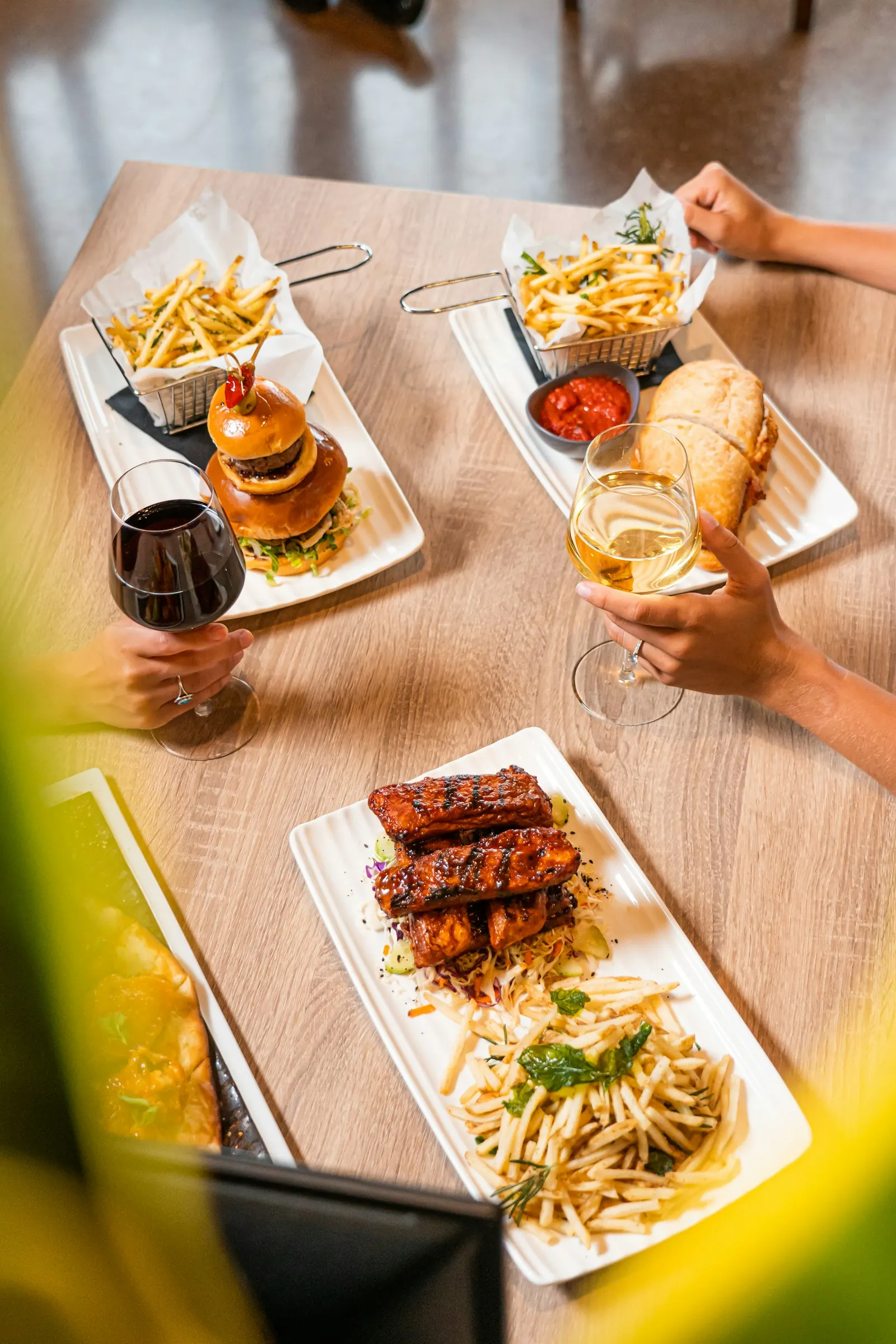 Gedeckter Restauranttisch mit Speisen, Wein und Cocktails