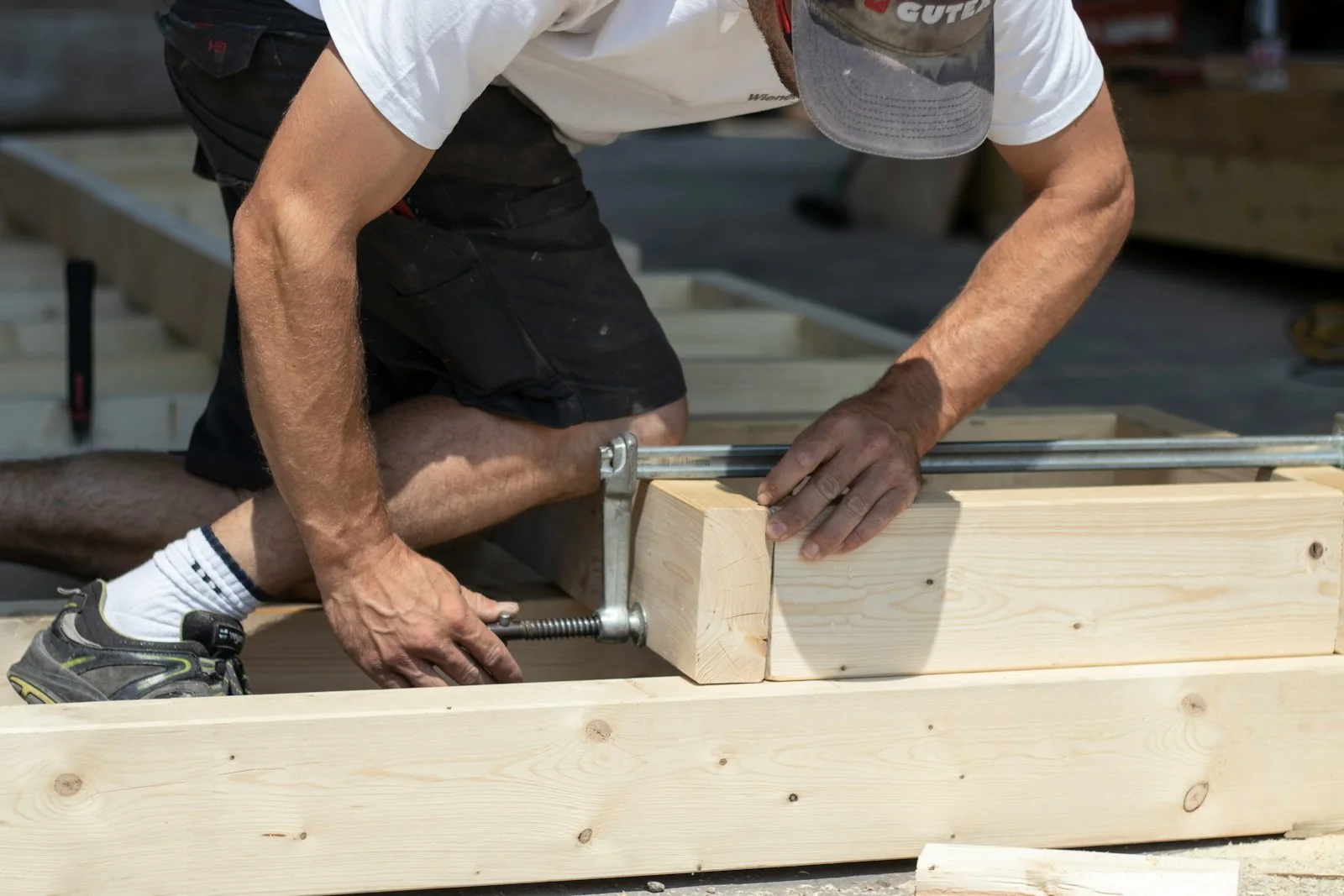 Nahaufnahme eines Handwerkers bei der Bearbeitung eines Holzstücks