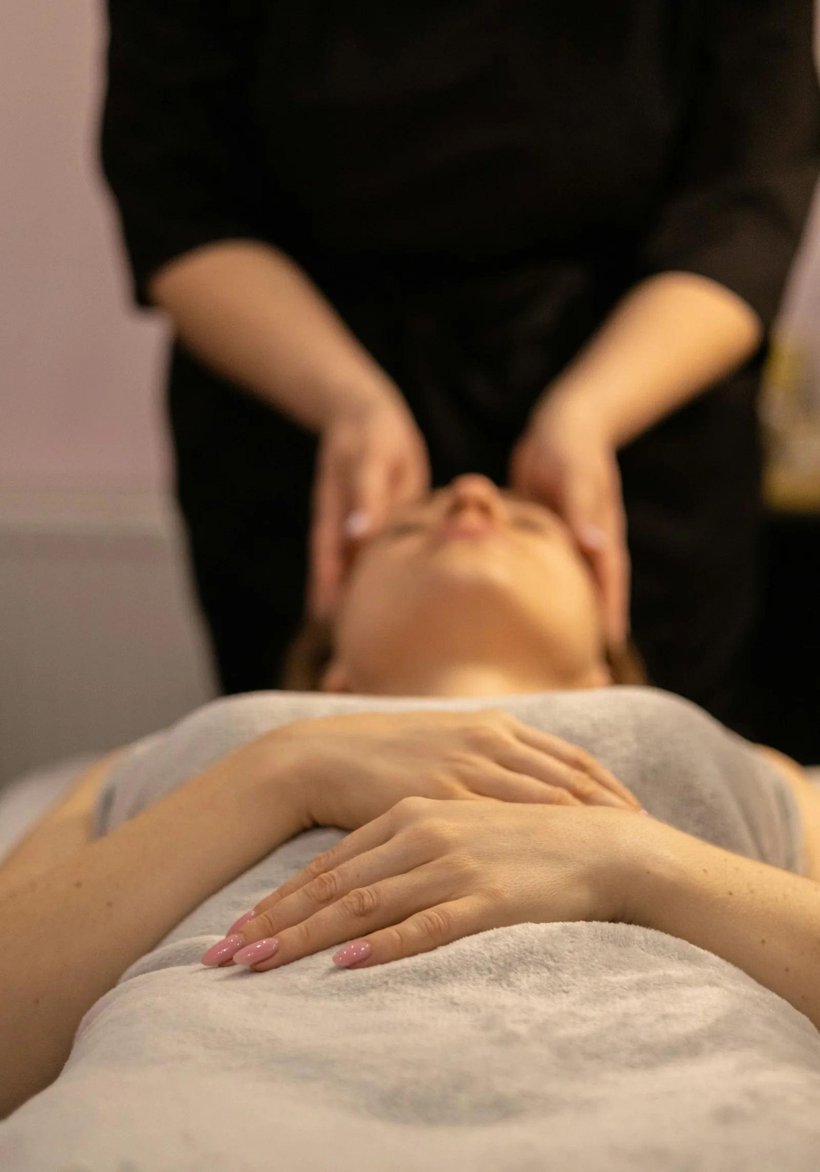 Ausschnitt einer entspannten Frau während einer Gesichtsmassage