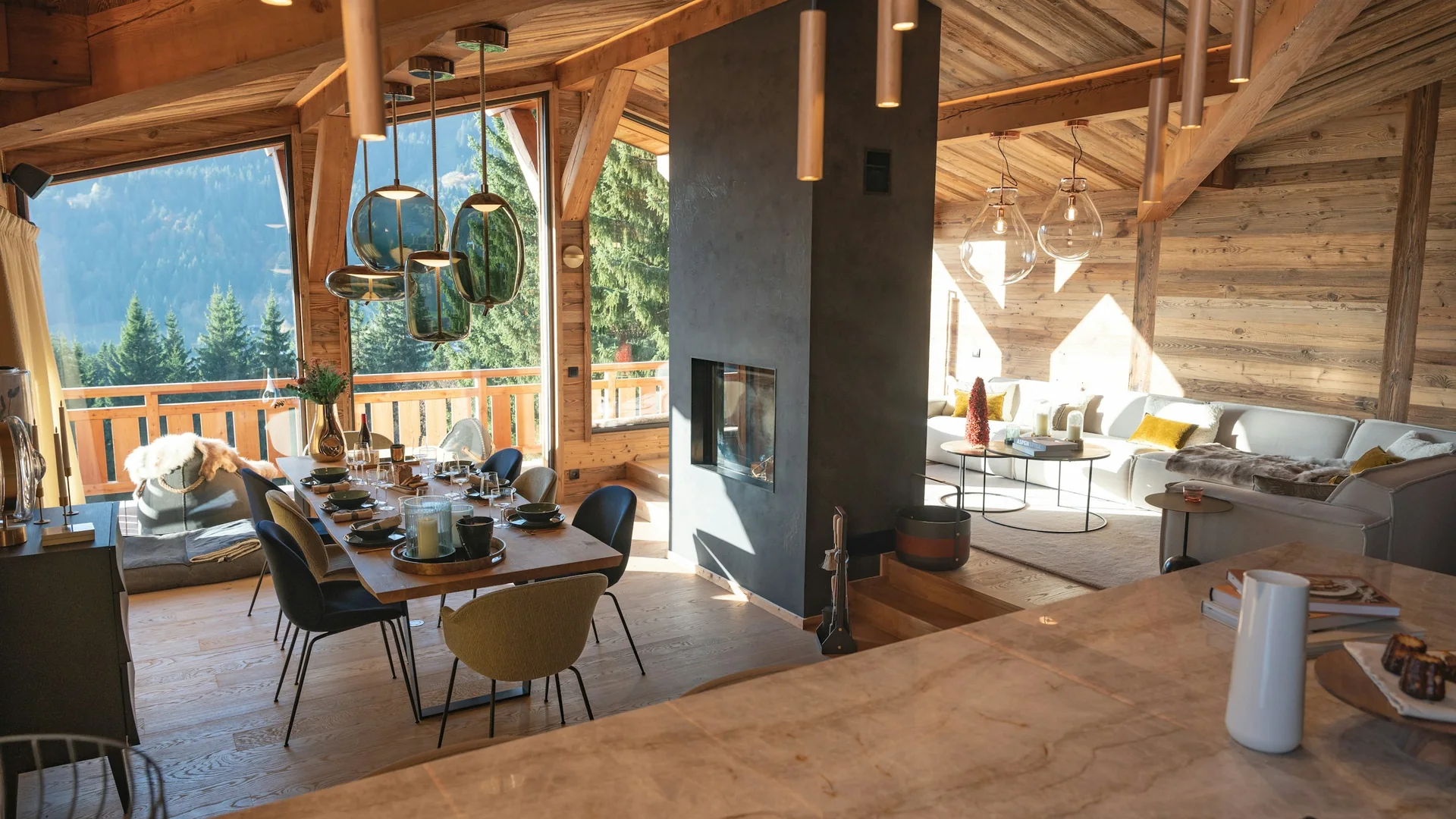 Wohn- und Essbereich eines Holzchalets mit warmer Holzgestaltung und Bergblick